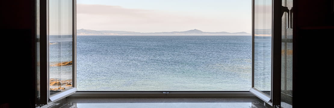 Open window overlooking calm ocean, symbolizing the health benefits of gratitude.